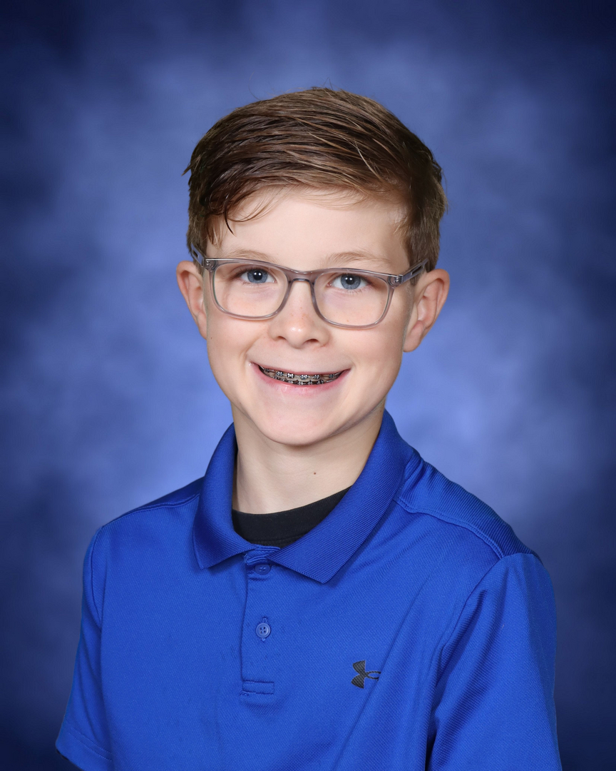 School portrait — boy in blue polo with glasses