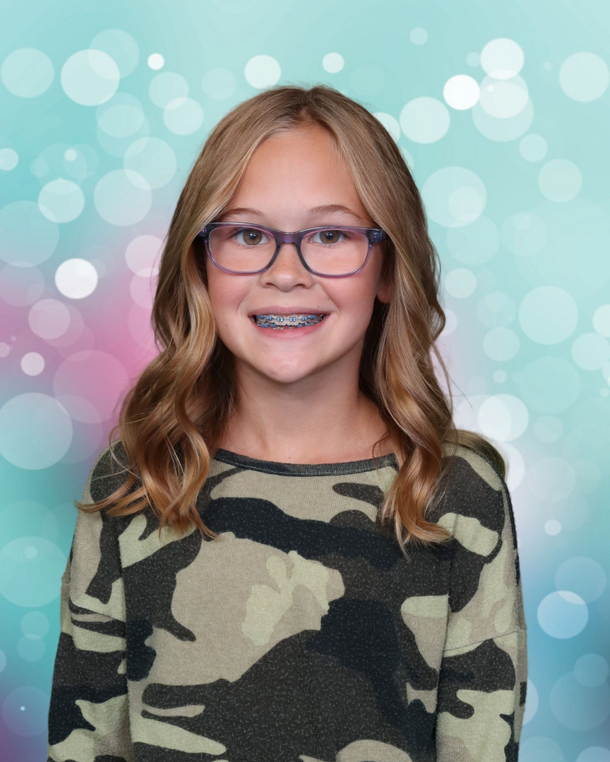 School portrait — girl with teal bokeh background