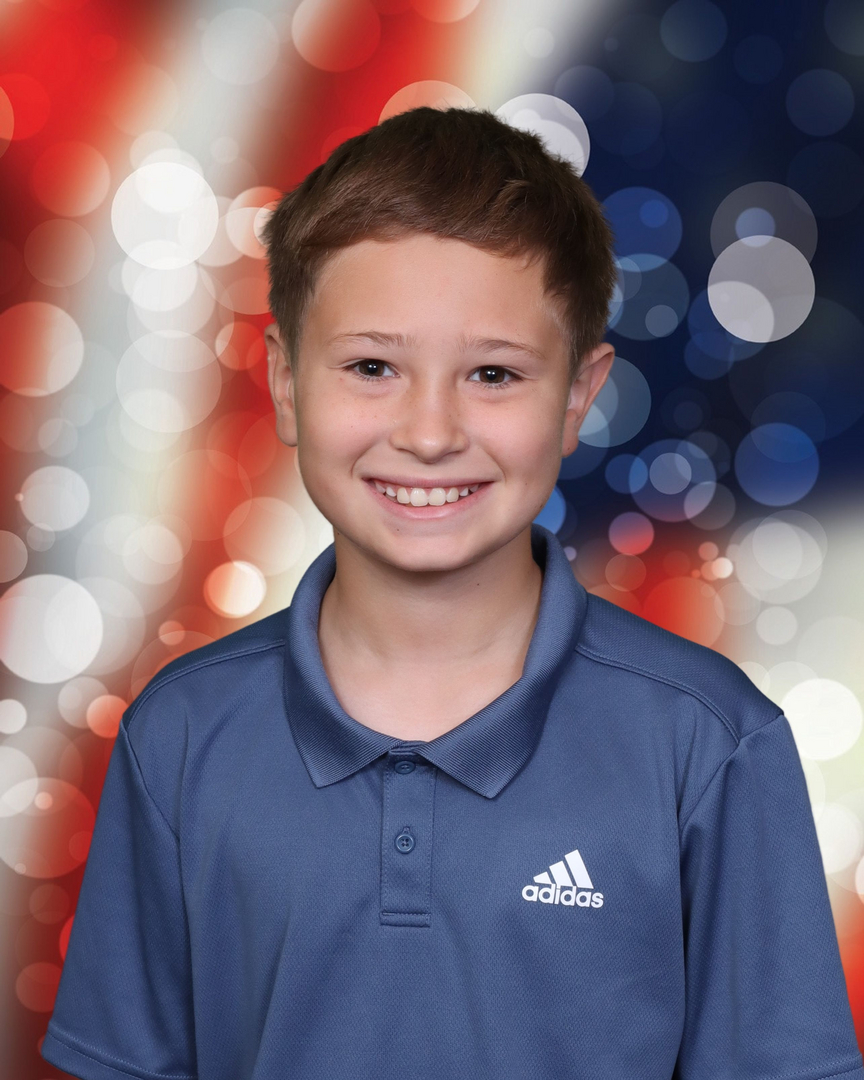 School portrait — boy with American flag backdrop